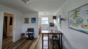 Une cuisine compacte équipée d’un four à micro-ondes, d’une petite table et d’une fenêtre.