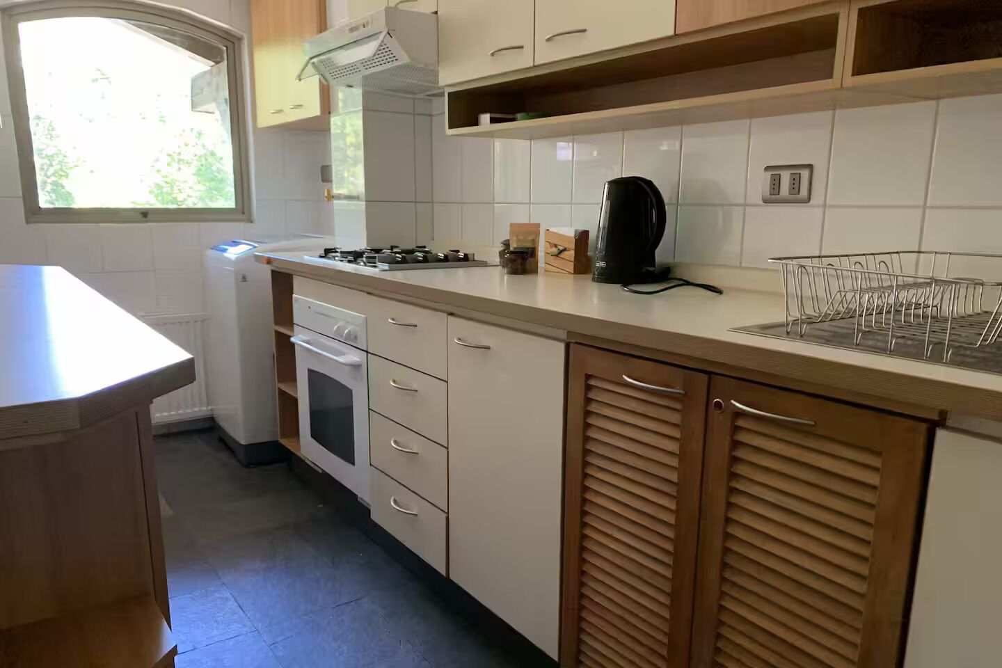 Een keuken met een fornuis, oven en kastjes.