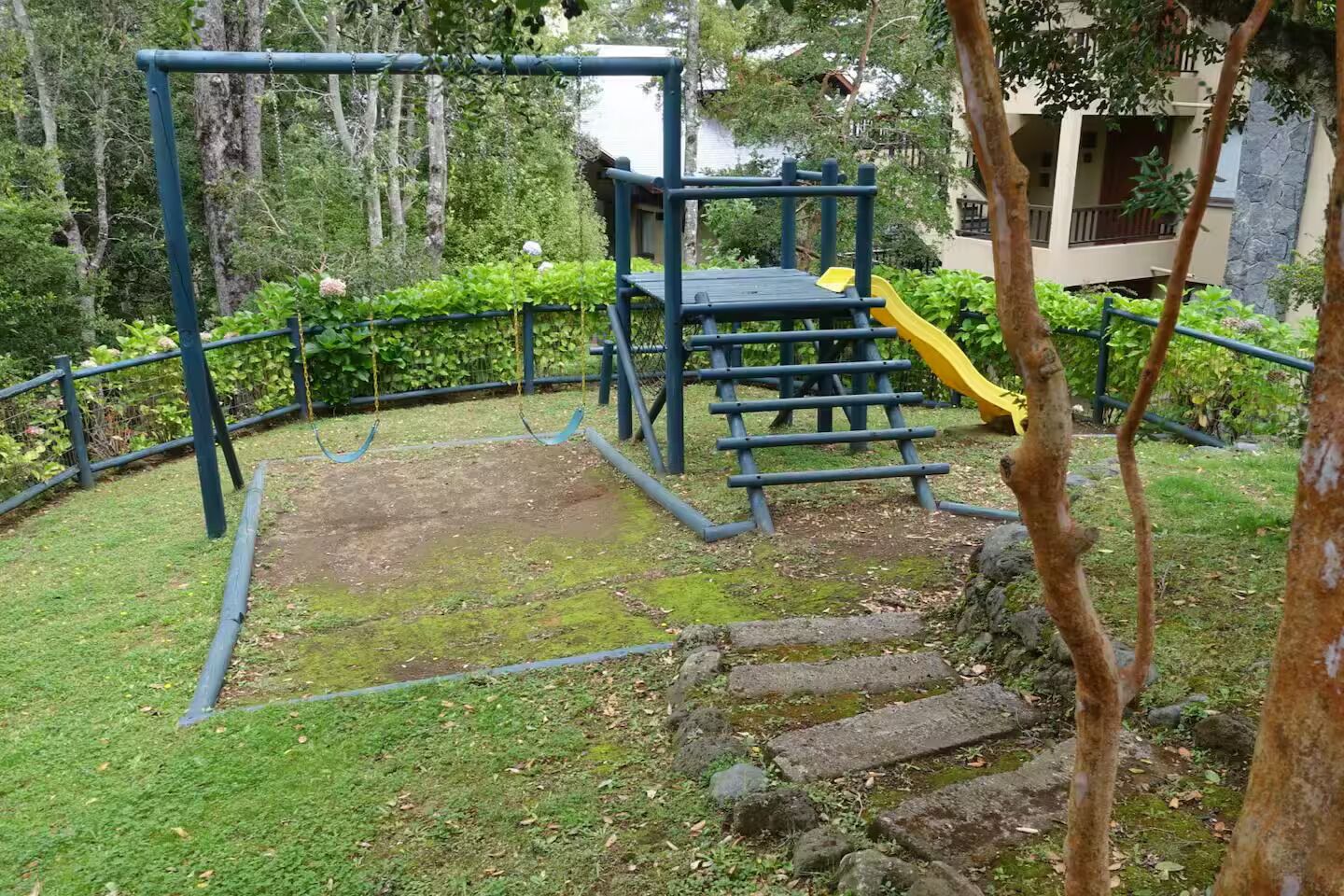 Une aire de jeux avec un toboggan, des structures d’escalade et des balançoires.