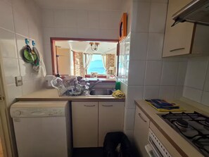 Una cocina compacta con lavavajillas, un lavabo y una estufa.