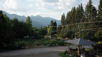 A rural setting with a gazebo, a paved area, and a mountain backdrop.