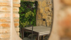 Un espace repas avec un mur en pierre, une table en bois et des chaises en métal.