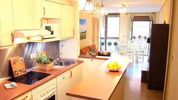 Una cocina moderna con una isla central, electrodomésticos de acero inoxidable y vistas al área de comedor.