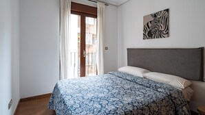 A bedroom with a bed, curtains, a zebra artwork, and a view of the outside. - Central, bright, and quiet (Madrid)