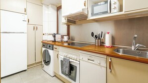 Eine kompakte Küche mit Mikrowelle, Toaster, Spüle und Geschirrspüler.