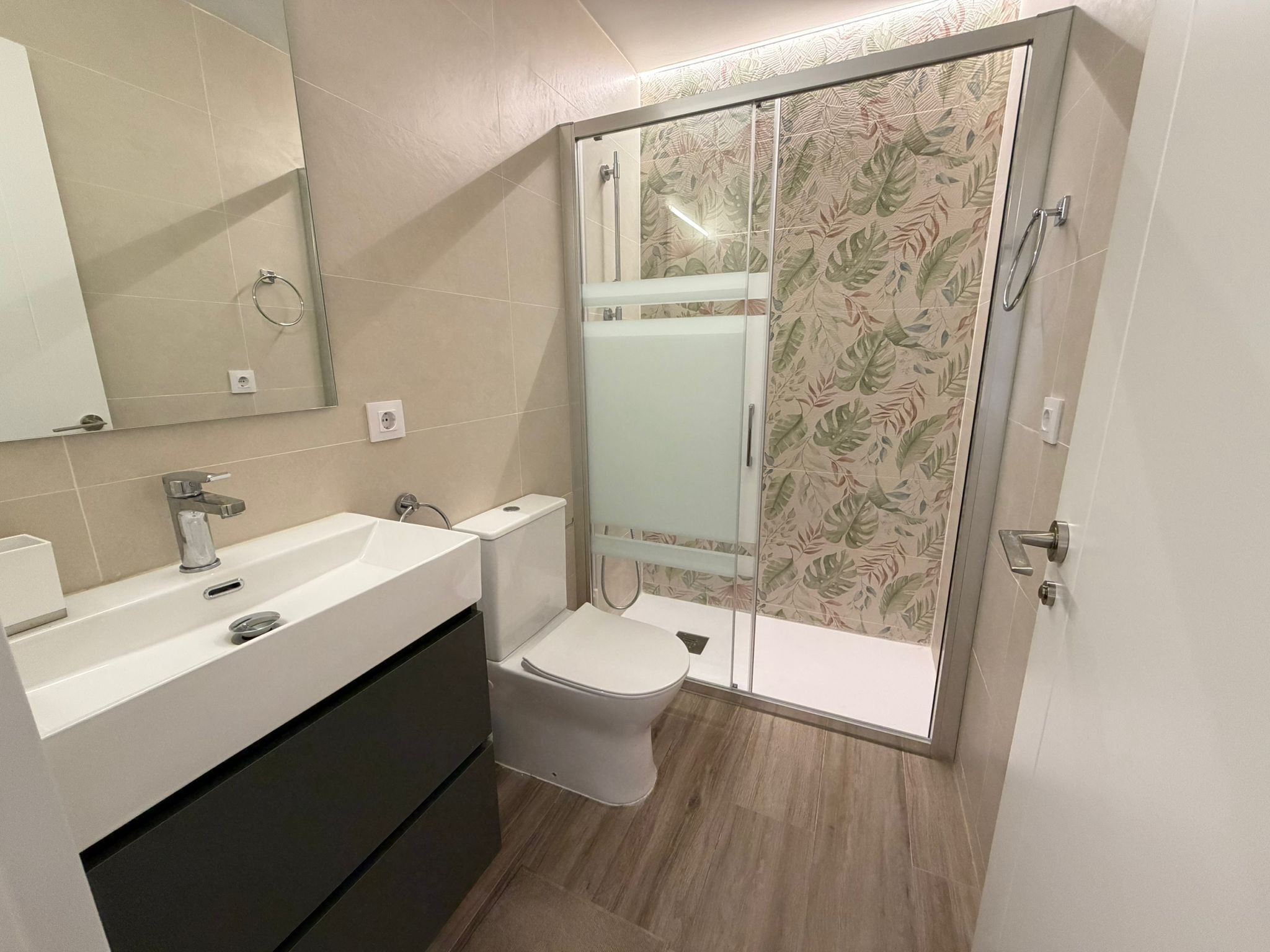 A bathroom with a shower, toilet, and sink.