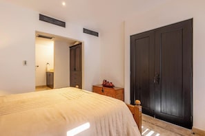 A bedroom with a bed, a wardrobe, a nightstand, and a door. - Live the Cabo Dream, Luxurious 5-bedroom Oceanfront Paradise in Cabo San Lucas (Cabo san lucas)