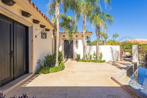 A house with a pool, palm trees, and a clear sky. - Live the Cabo Dream, Luxurious 5-bedroom Oceanfront Paradise in Cabo San Lucas (Cabo san lucas)