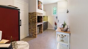 A kitchen with a brick fireplace, white cabinets, and a window.