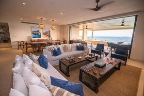 Ein geräumiges Wohnzimmer mit großem Sofa, Couchtisch und Essbereich.