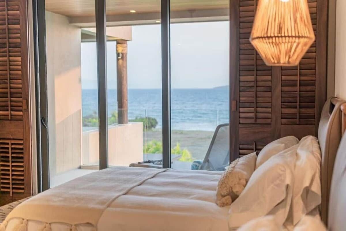 Ein Schlafzimmer mit einem großen Bett, Meerblick und einer Hängelampe.