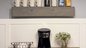 Eine Küchenarbeitsplatte mit Kaffeemaschine, einem Korb und einer Vase.