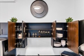 Una cocina moderna con alacenas abiertas que exhiben cristalería y vajilla.
