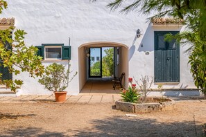 A white building with a wooden door and windows, a bench outside, and potted plants. - Nona Dimora Del Pizzo - Gallipoli (Gallipoli)
