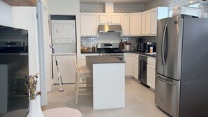 A modern kitchen with white cabinetry, stainless steel appliances, and a central island. - NEW! Boutique Coastal home Steps from the Beach (Marina del Rey)