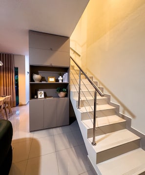 A modern interior with a staircase, a built-in bookshelf, and a dining area. - Milyleo Home, Your Caribbean Hideaway – Private Jacuzzi & Tropical Comfort (Punta Cana)