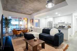 Ein modernes Wohnzimmer mit Sofa, Couchtisch und Essbereich.
