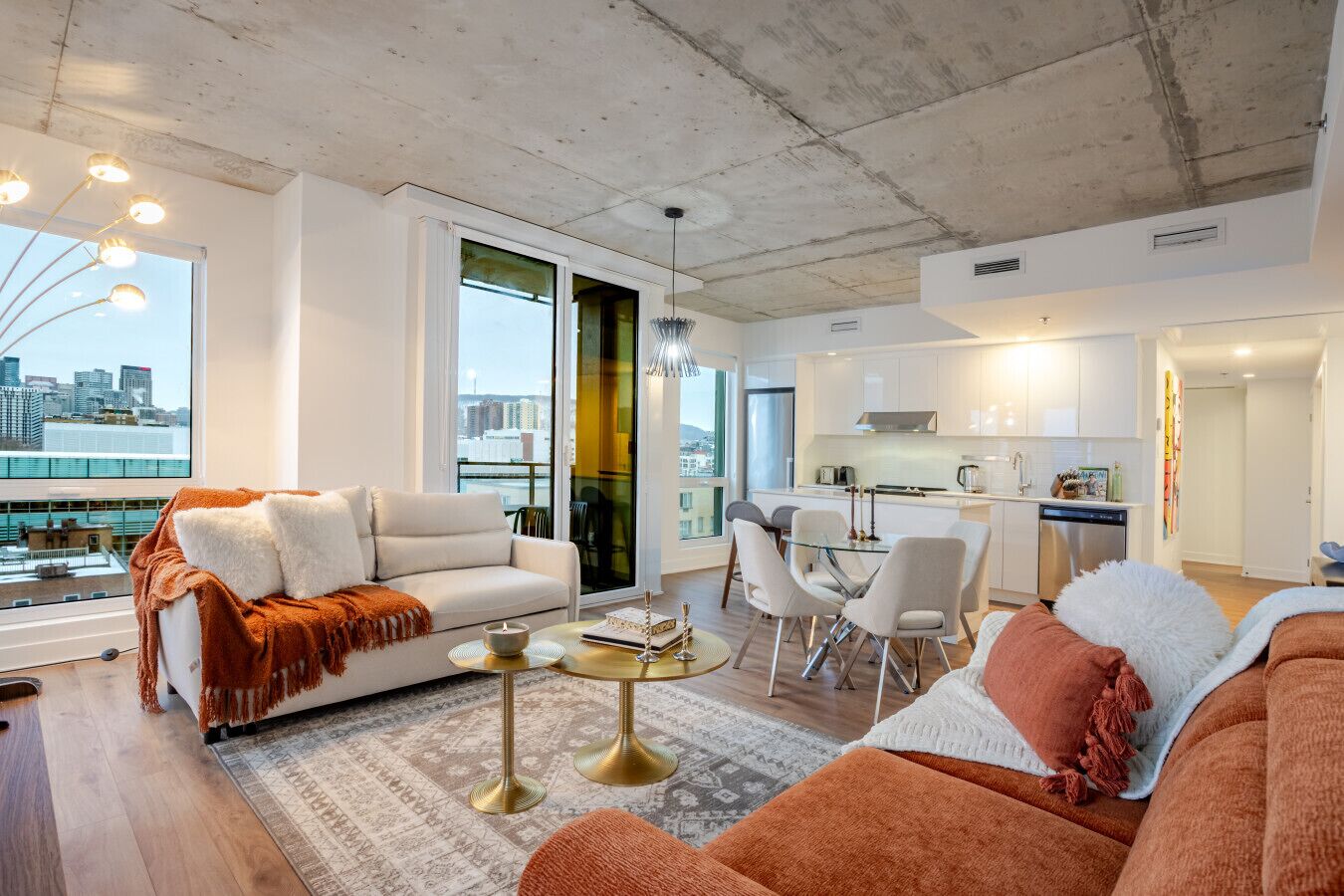 A modern living room with a sofa, coffee table, and dining area.