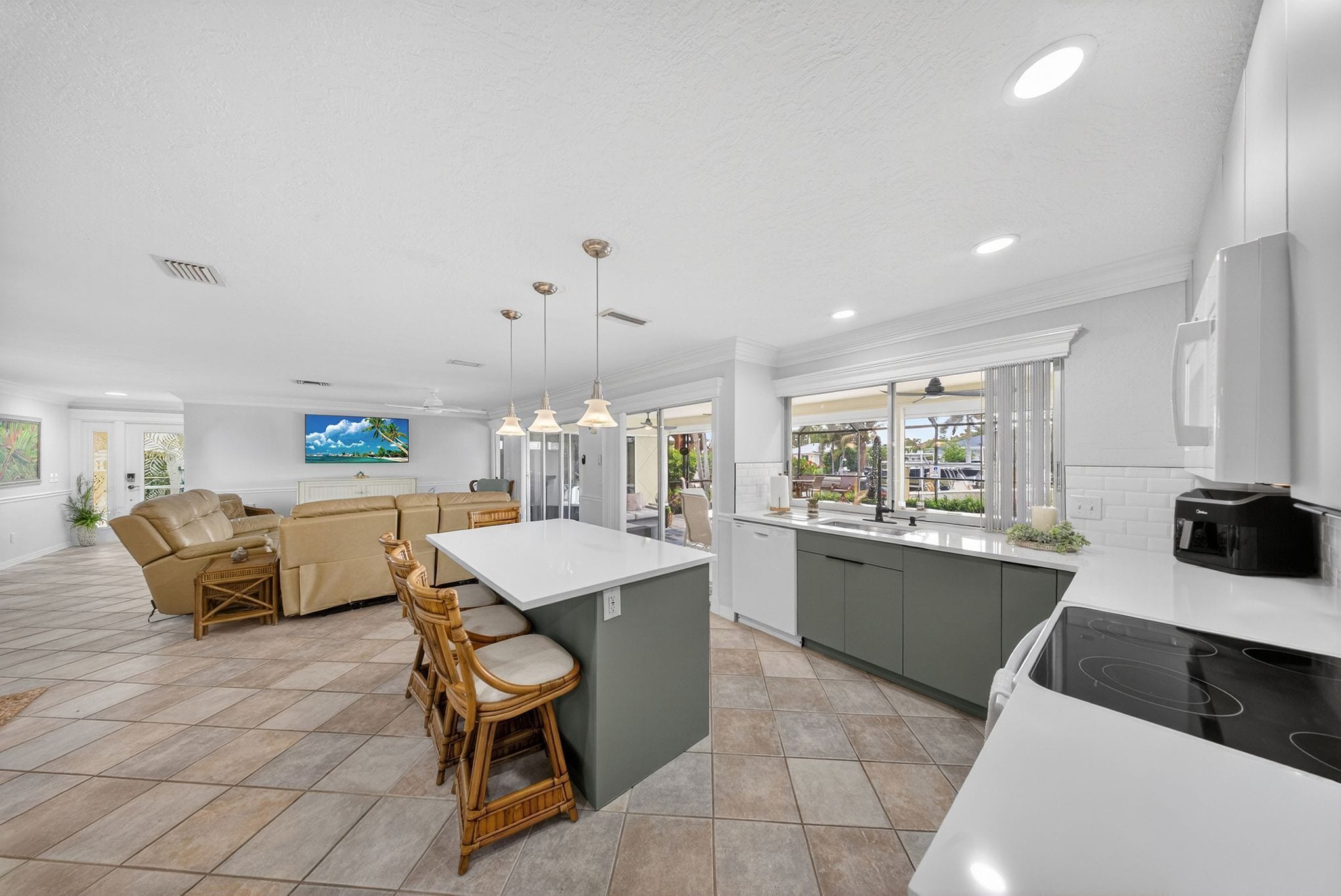 A spacious living area with a sofa, dining table, and kitchen island.