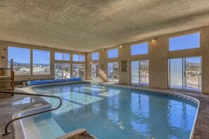 Ein Innenpool mit Blick auf eine Wüstenlandschaft durch große Fenster.