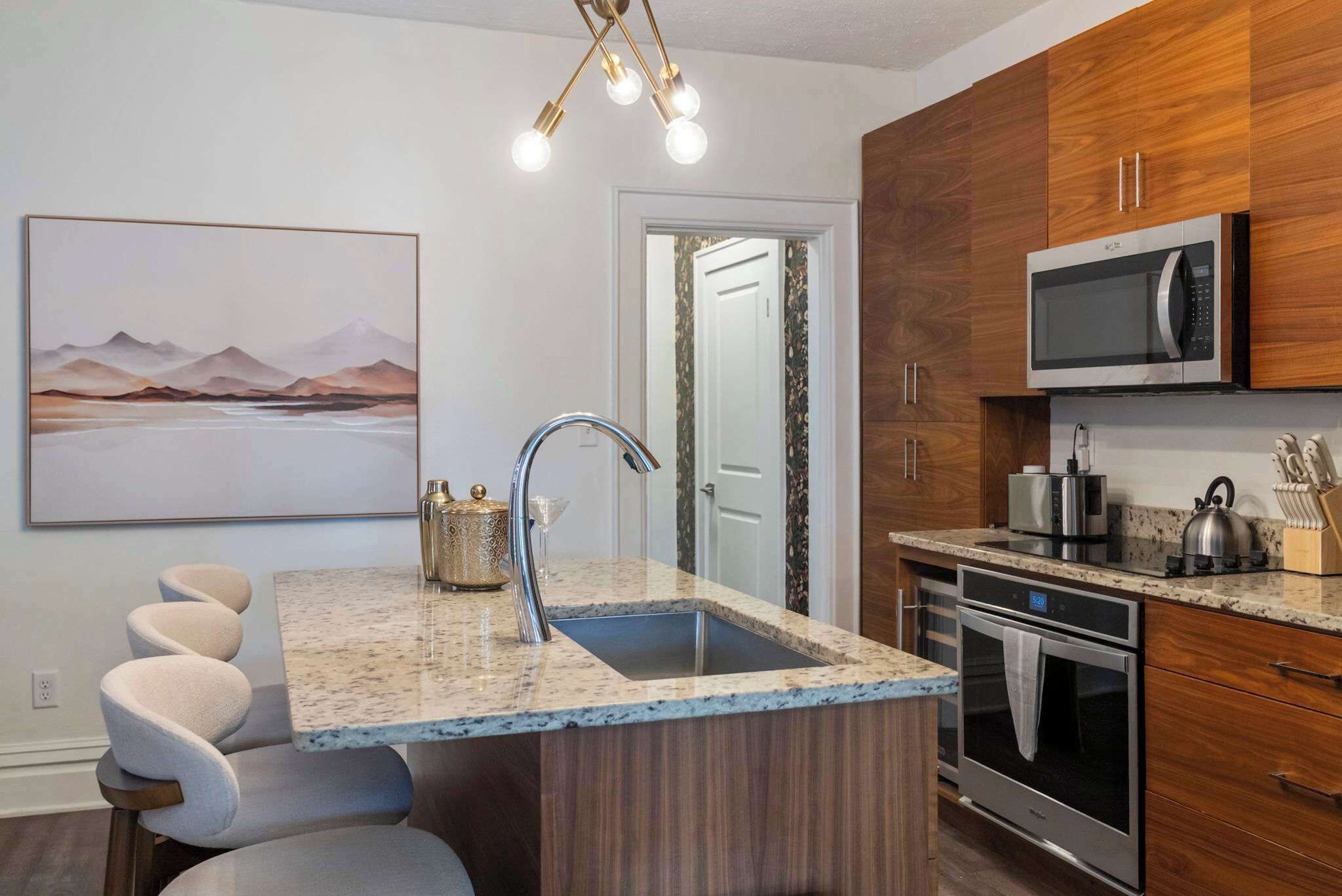 Una cocina moderna con encimera de granito, electrodomésticos de acero inoxidable y un armario de madera.