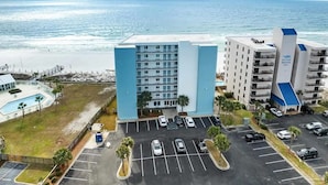 A hotel with a pool, parking lot, and ocean view. - Oceanfront Condo, Gated Entry, Pool, King Bed, <100 Steps to Sand.  (Pensacola)
