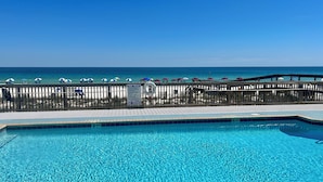 A clear blue pool with a wooden deck and a view of the beach. - Oceanfront Condo, Gated Entry, Pool, King Bed, <100 Steps to Sand.  (Pensacola)