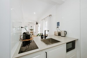 A modern kitchen with a built-in oven, a sink, and a coffee maker. - Ash Cottage Intimate Wine Country Living for Two (Mudgee)