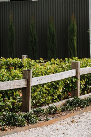 A wooden fence with greenery behind it. - Luxe Loft Contemporary Comfort by Mudgees CBD (Mudgee)