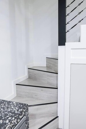 A staircase with a modern design, featuring a light wood finish and black accents. - Luxe Loft Contemporary Comfort by Mudgees CBD (Mudgee)