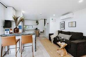 A modern apartment with a kitchen, dining area, and living room. - Claret on Douro Three Cottages for Group Getaways (Mudgee)