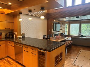 A modern kitchen with wooden cabinets, a granite countertop, and pendant lighting. -  Greyhawk on Blueberry Hill —  2 bdrm 2 bath with private balcony (Whistler)