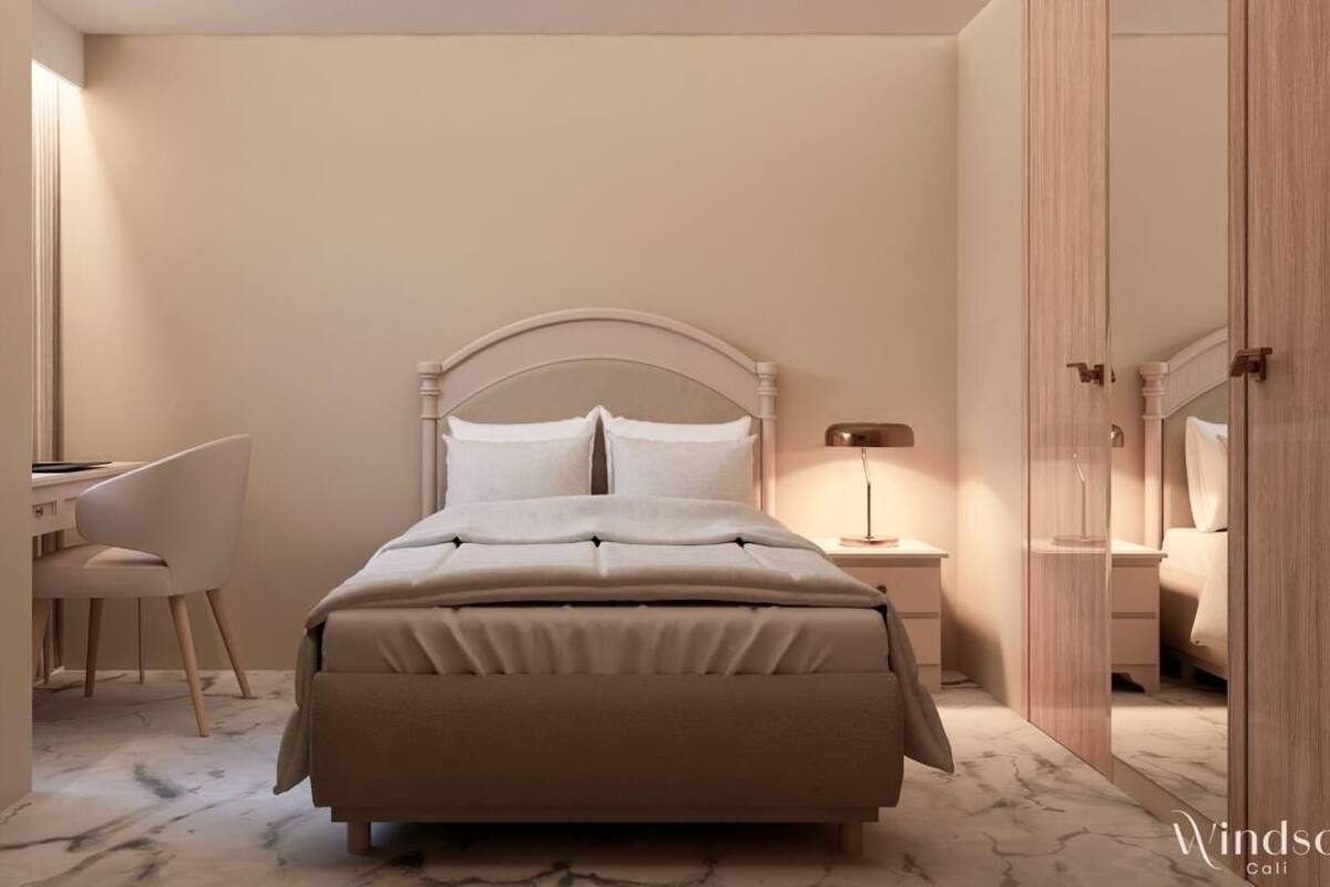 A bedroom with a bed, a desk, and a chair.