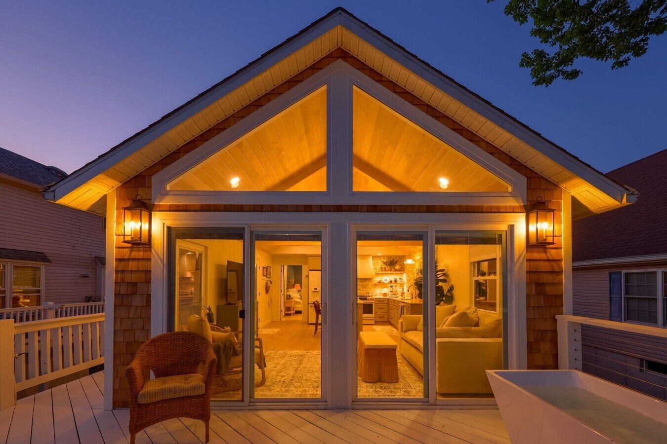 Une maison dotée d’un porche couvert, d’un coin repas et d’une cuisine visible à travers des portes vitrées.