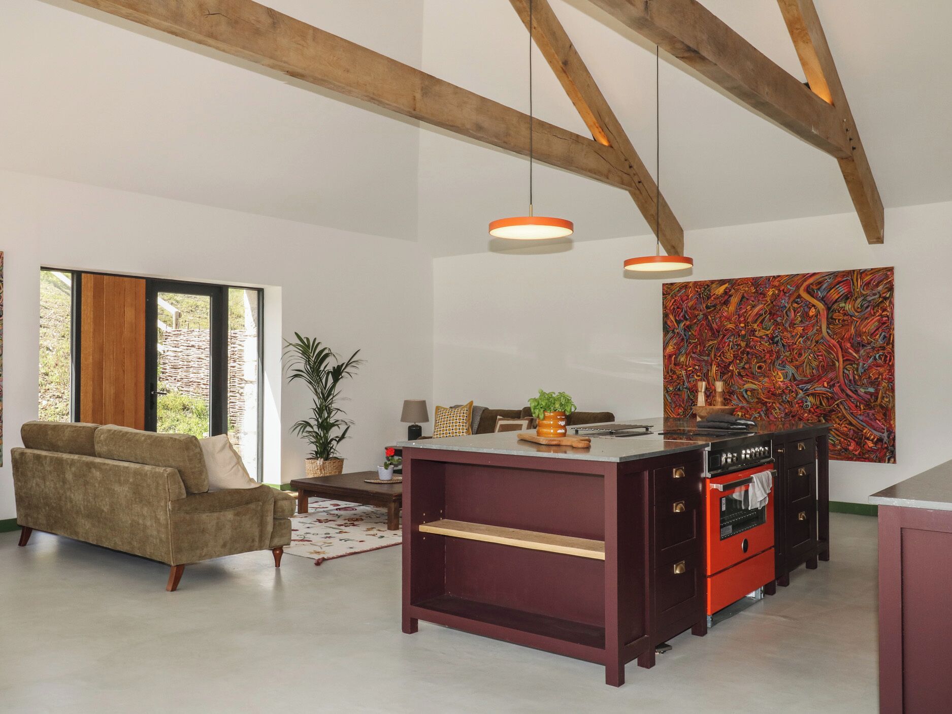 Un salón amplio con sofá, mesa de comedor y una isla de cocina.