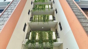 A multi-story building with balconies, some with greenery. - Serene Stay at Paseo Verde (Las Piñas)