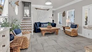 A spacious living area with a sofa, coffee table, and wicker furniture. - Ocean Views, 5 min walk to Beach, Waterpark, Arcade, Store ~ 5 bd/3; Sleeps 10 (Myrtle Beach)