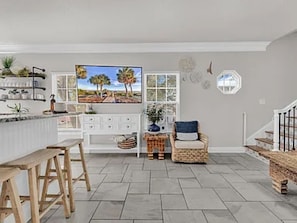 A spacious living area with a kitchen, a television, and a comfortable seating area. - Ocean Views, 5 min walk to Beach, Waterpark, Arcade, Store ~ 5 bd/3; Sleeps 10 (Myrtle Beach)