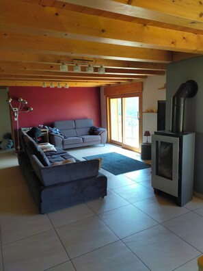 Una sala de estar con sofá, chimenea y ventana grande.