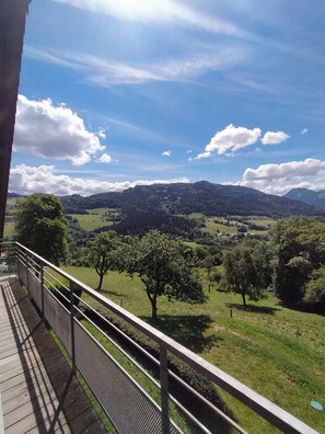A balcony with a view of a green landscape, trees, and distant hills. - A country house in a quiet location on the edge of the woods. (Viuz-en-Sallaz)