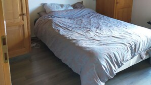 Une chambre à coucher avec un lit, des armoires en bois et un plafond en bois.