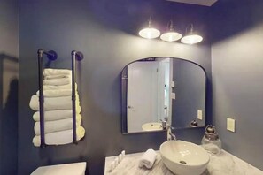 A bathroom with a white sink, a large mirror, and a towel rack with folded towels. - Lakeview 3 BR Townhome with Fireplace and Deck (Lake Harmony)