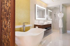 Une salle de bain moderne avec une baignoire sur pieds, un grand miroir et un peignoir accroché à une porte.