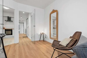 Ein modernes Interieur mit einer Küche, einem Essbereich und einer Sitzecke mit einem großen Spiegel.