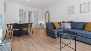 Uma sala de estar moderna com uma mesa de jantar redonda, um sofá e uma mesa de centro.