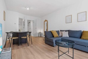 Ein modernes Wohnzimmer mit einem runden Esstisch, einer Couch und einem Couchtisch.