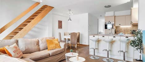 A modern living room with a sofa, coffee table, and a staircase.