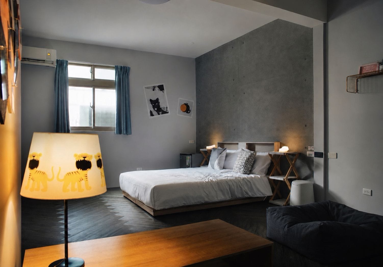 Un dormitorio moderno con una cama, mesitas de noche, una lámpara y un sofá.