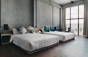 Ein modernes Hotelzimmer mit zwei Betten, einem großen Fenster und einem minimalistischen Design.