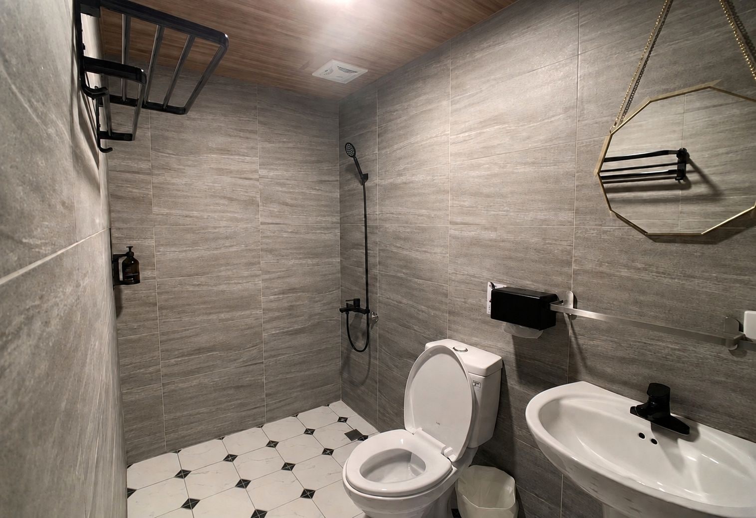 A modern bathroom with a shower, toilet, and sink.